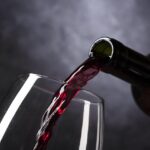 Bicchiere di vino rosso su tavolo, simbolo di salute cardiaca e consumo moderato.
