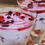 Immagine di vari tipi di yogurt alla frutta con etichette sugli ingredienti e avvertenze sulla glicemia.