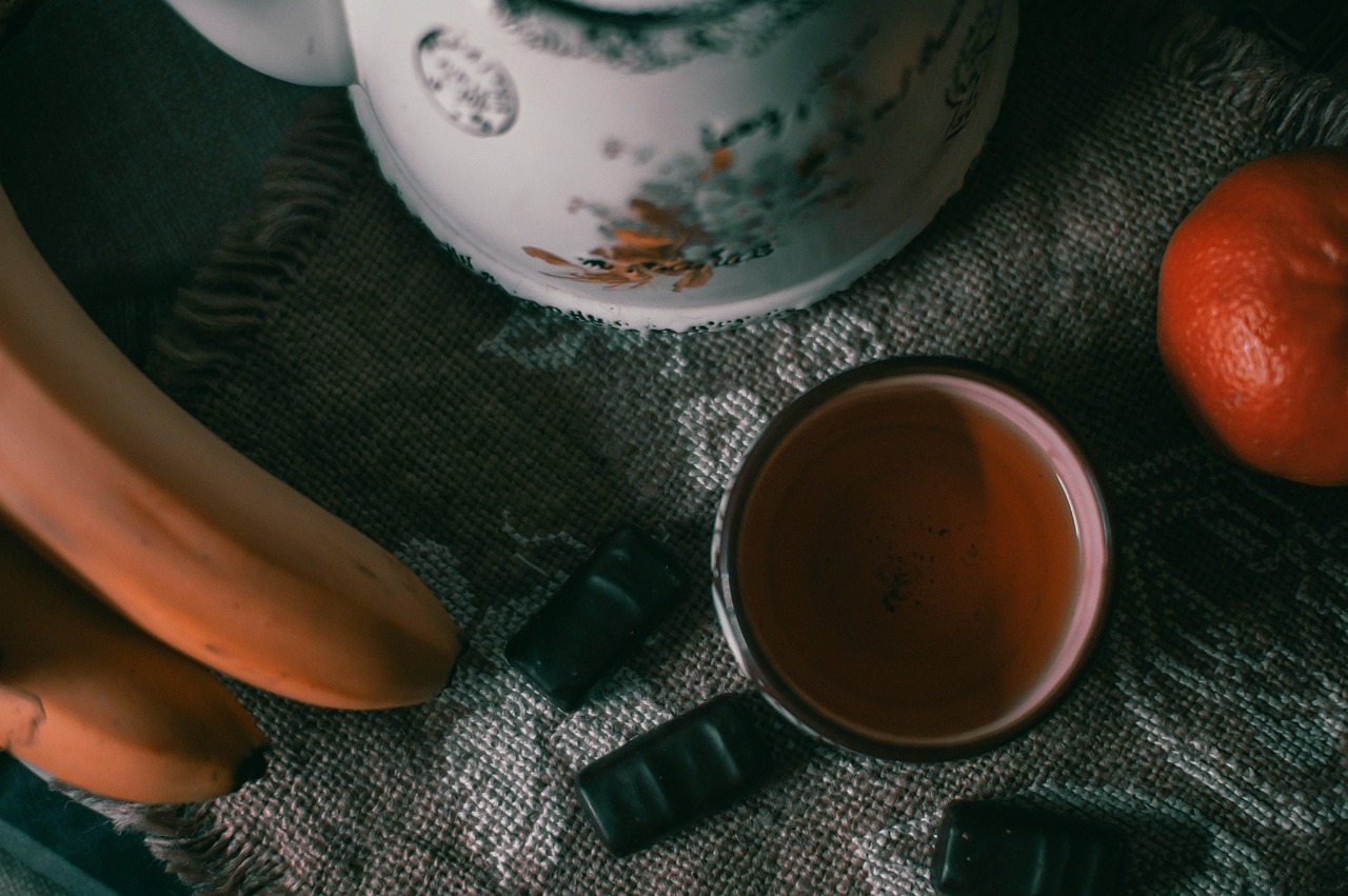 Tazza di tè verde fumante con foglie di tè e limone, simbolo di un metabolismo attivo e sano.