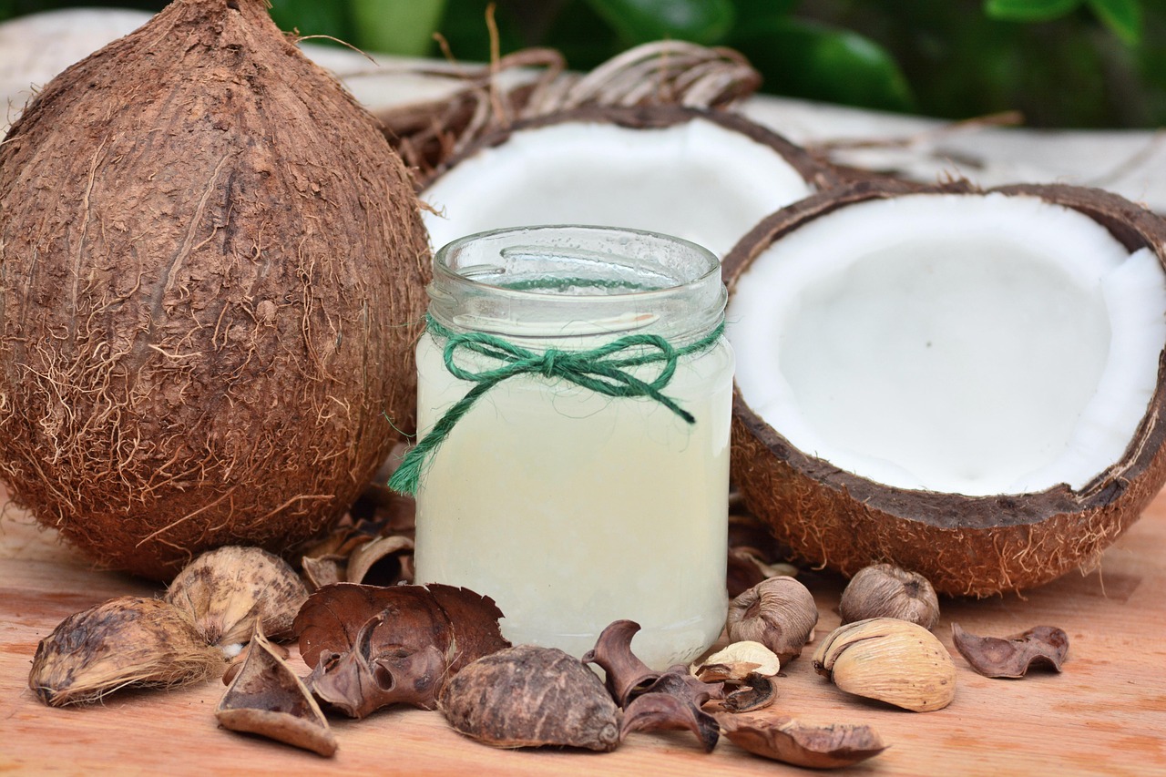 Olio di cocco versato in un cucchiaio su sfondo naturale, simbolo di salute e metabolismo.