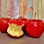 Mele fresche su un tavolo, simbolo di salute per il cuore e riduzione del colesterolo.