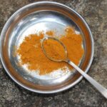 Curcuma in polvere su un tavolo, simbolo della spezia che aiuta a combattere il fegato grasso.