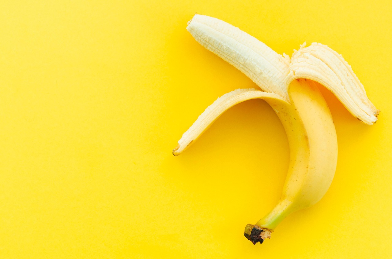 Banane mature su un tavolo, simbolo di salute intestinale e rimedio contro la stipsi.