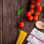 Pasta al pomodoro servita in un piatto con foglie di basilico fresco.