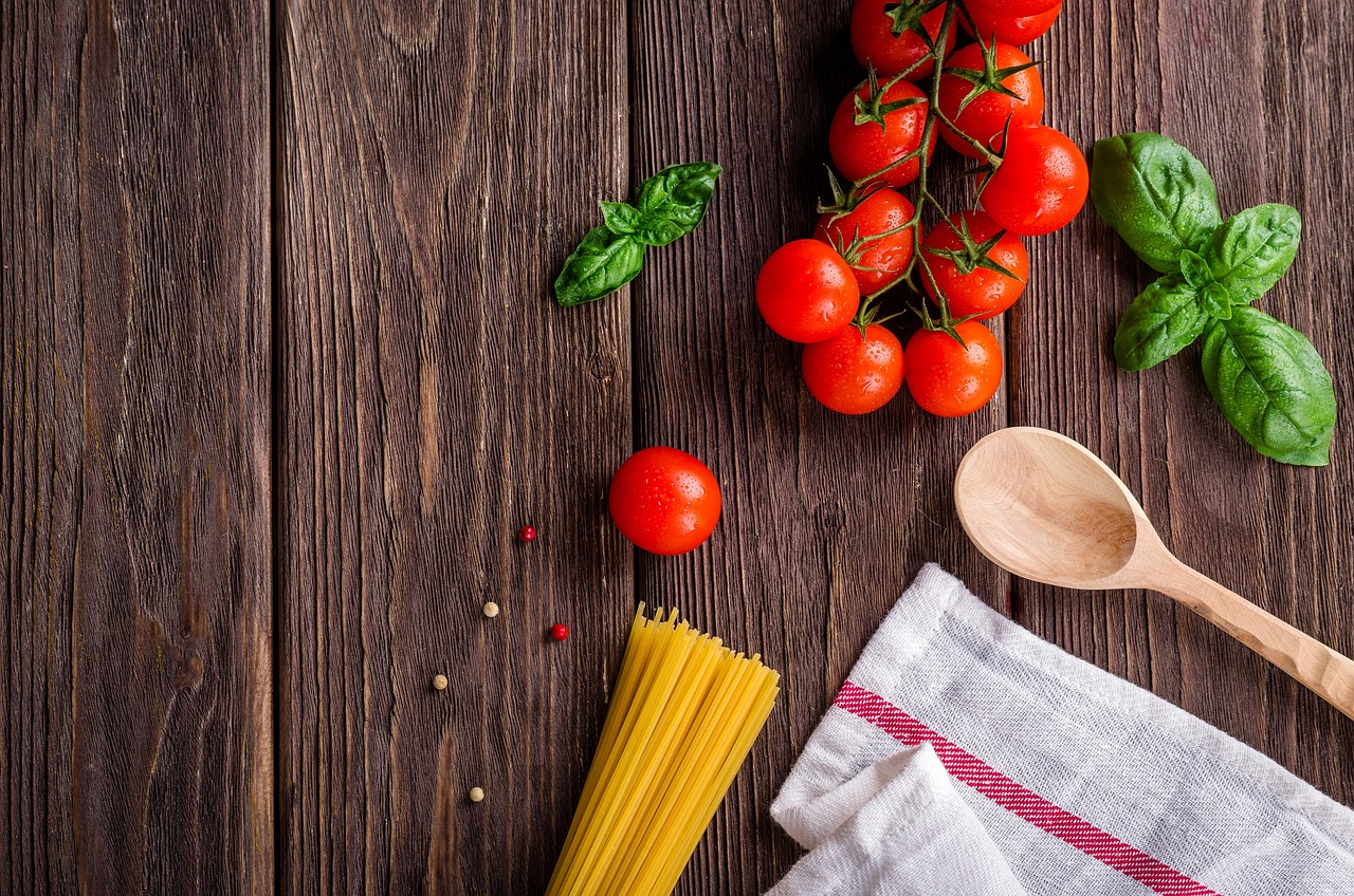 Pasta al pomodoro servita in un piatto con foglie di basilico fresco.